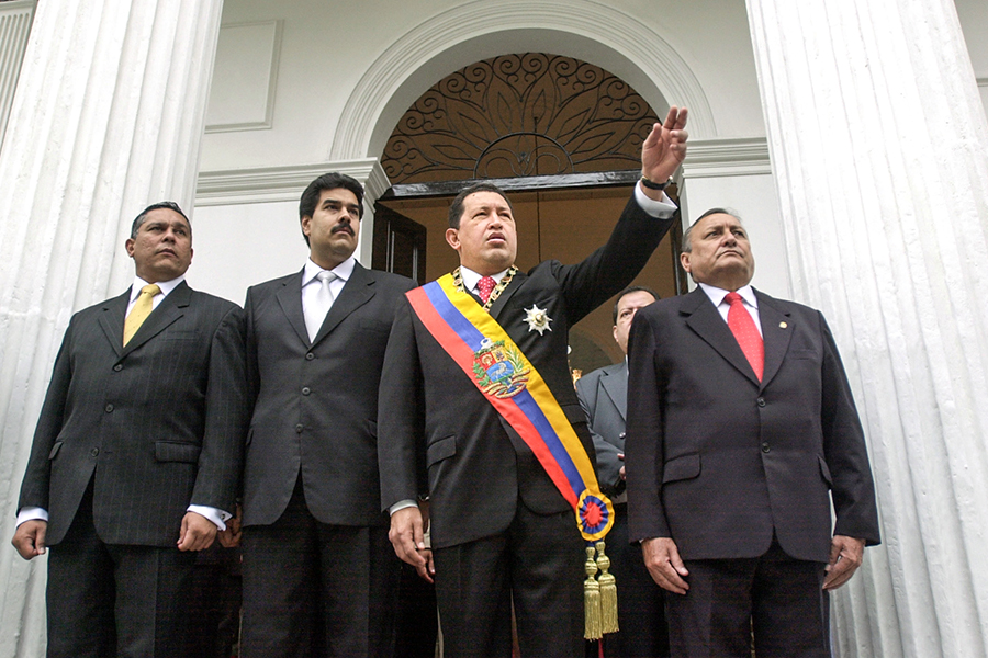 Президент Венесуэлы Уго Чавес (в центре) назвал Николаса Мадуро (слева) своим преемником в 2012 году. После смерти Чавеса от рака в 2013 году Мадуро стал и.о. президента. Через месяц он официально избрался на пост главы государства, набрав чуть более 50,75% голосов.
