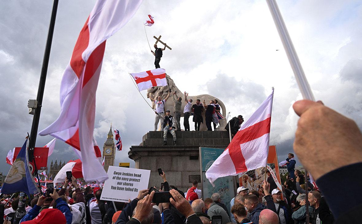 Протестующие взбираются на статую у Вестминстерского моста в день антииммиграционного митинга, Лондон, Великобритания, 13 сентября 2025 года