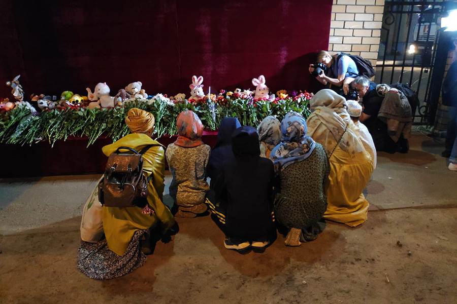 Группа девушек встала на колени у мемориала и начала молиться