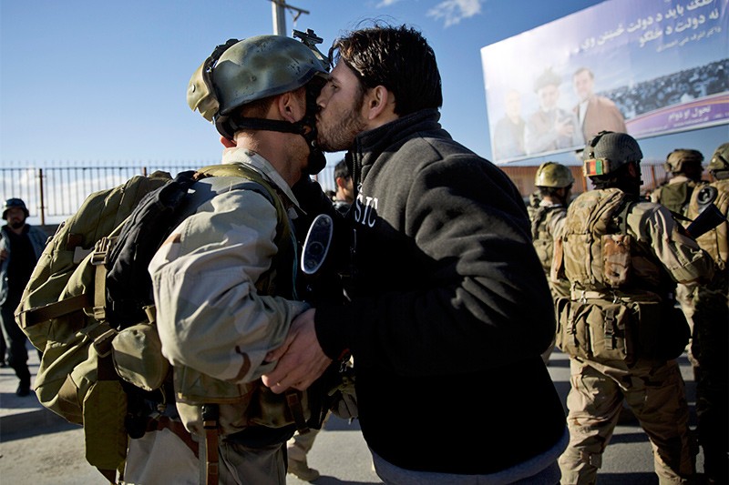 25 марта 2014 г.Житель Кабула целует спецназовца после того, как полицейские освободили здание избиркома от талибов. При атаке боевиков погибли несколько десятков человек.
