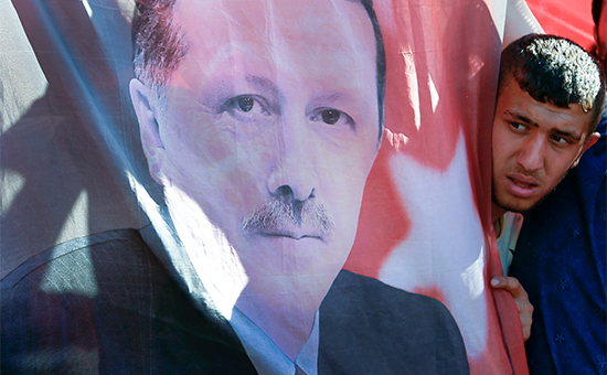Сторонник президента Турции Реджепа Тайипа Эрдогана&nbsp;рядом с его портретом. 16 июля 2016 года, Анкара


