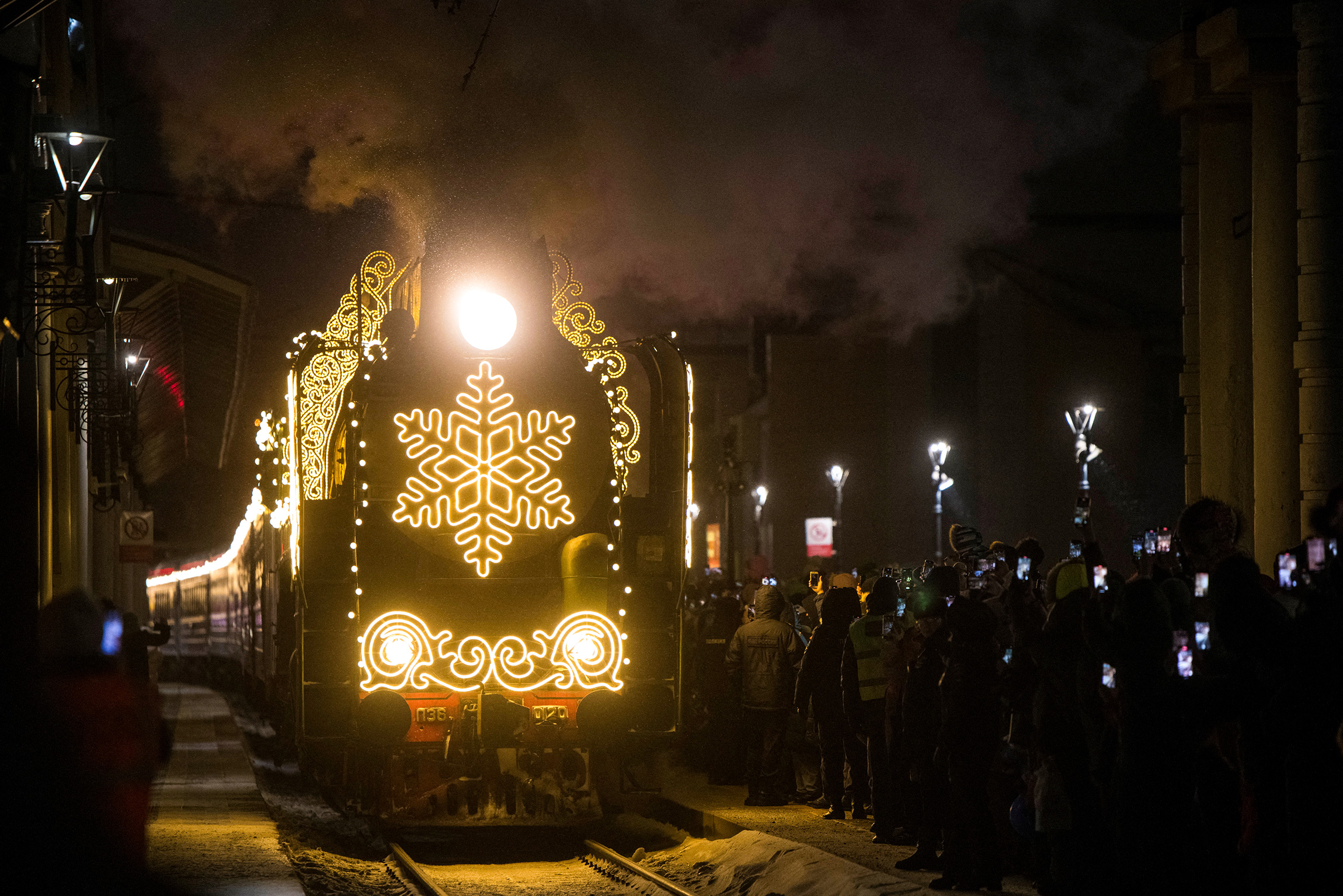 Люди встречают прибытие поезда Деда Мороза в Красноярске, Россия. Поезд стартовал из Великого Устюга еще в ноябре, в его маршруте более чем 80 городов