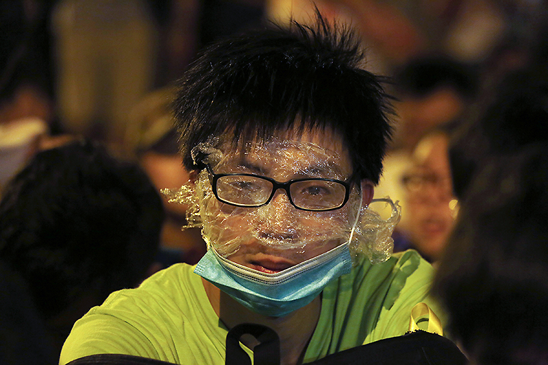 Один из протестующих надел маску и обмотал глаза полиэтиленовой пленкой, чтобы защититься от перцового газа, применяемого полицией при разгоне демонстрантов.