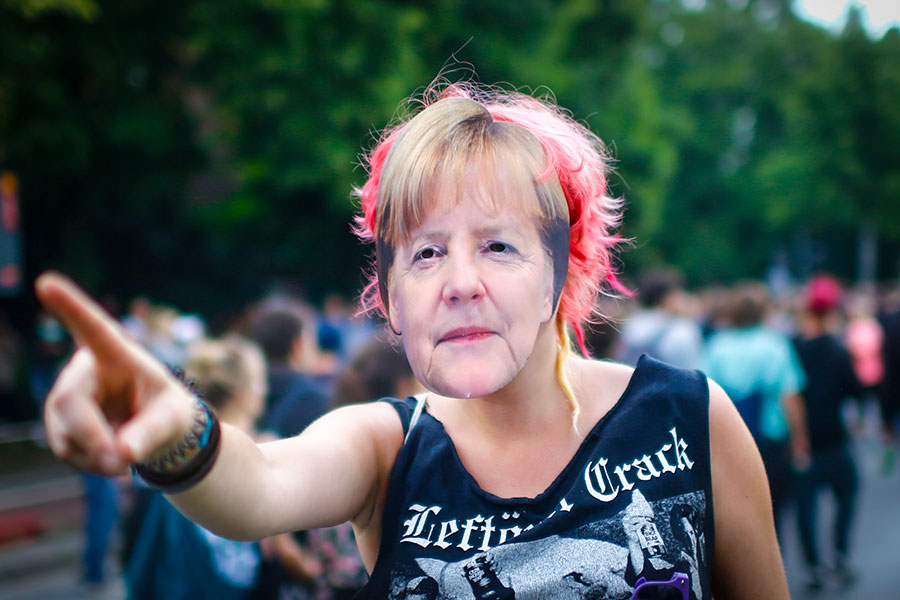 Девушка в маске с изображением канцлера Германии Ангелы Меркель. Гамбург, Германия.&nbsp;5 июля
