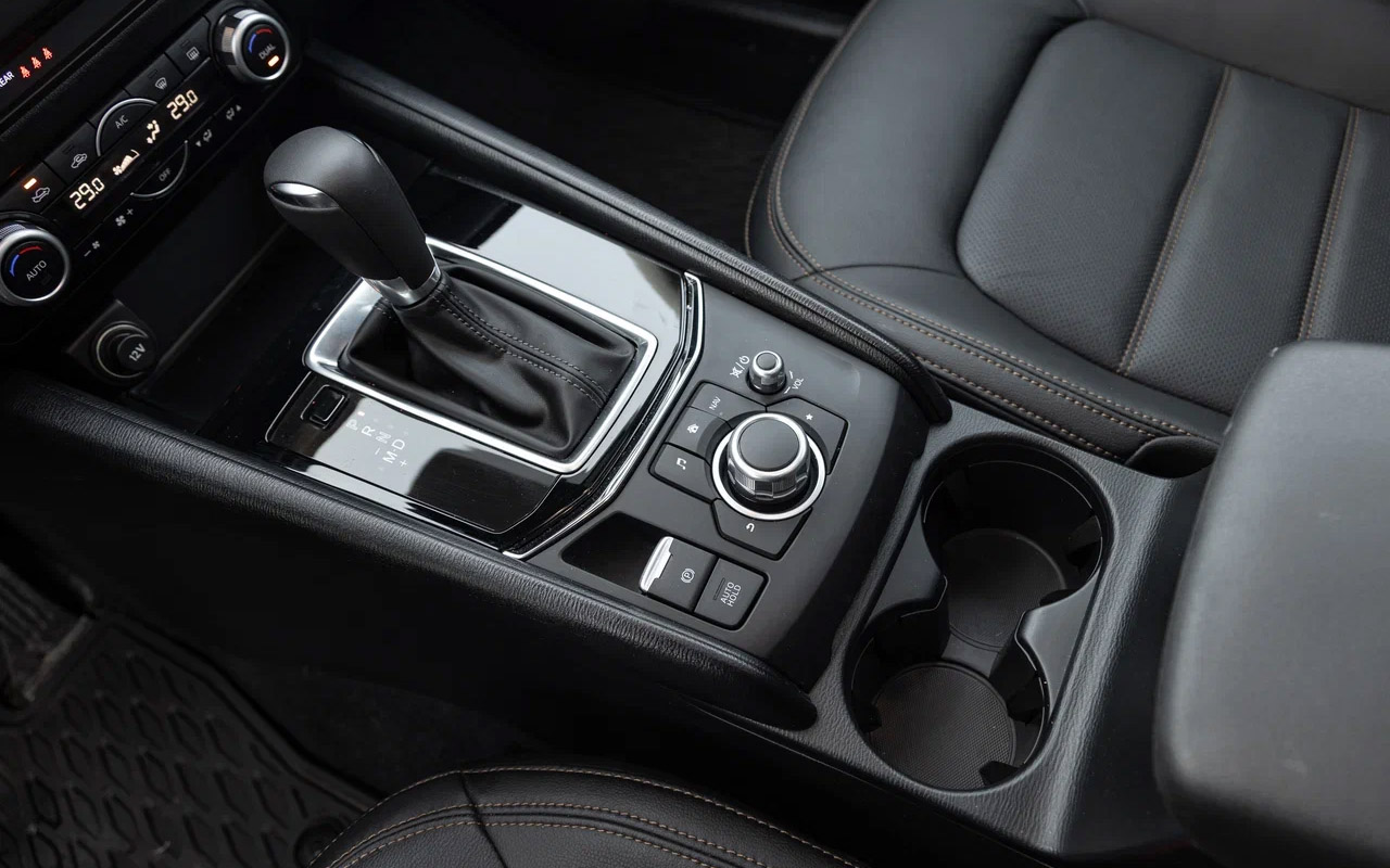 На месте кнопок и шайб мультимедийной системы на&nbsp;Mazda CX-5 могли бы быть клавиши, что поместили под торпедо слева от руля. Жаль, так не получилось из-за устаревшей мультимедиа