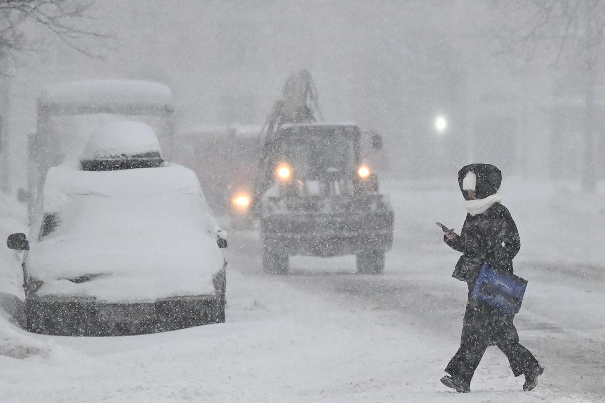 Девушка идет во время снегопада по улице в Москве, 9 января 2026 года