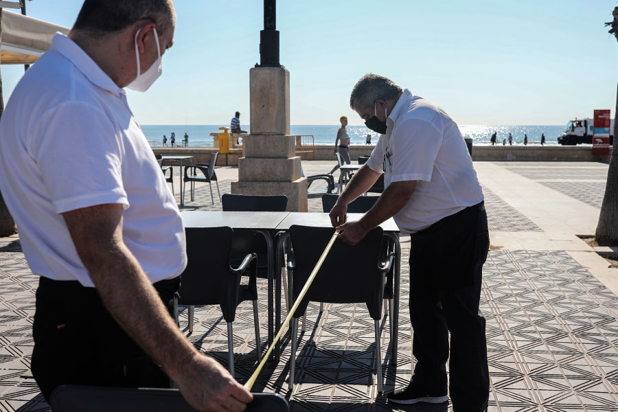 Официанты ресторана в Валенсии измеряют дистанцию между столиками.
&nbsp;
