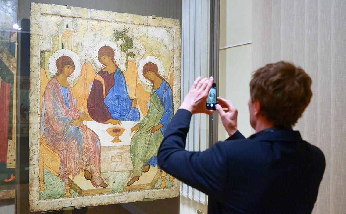 Молодой человек фотографирует икону художника Андрея Рублева «Троица» в Третьяковской галерее