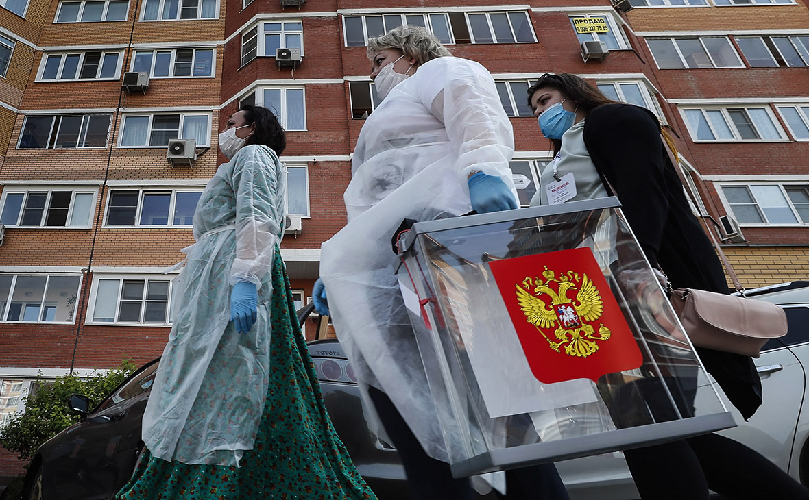 Сотрудники участковой избирательной комиссии с переносным ящиком для голосования
