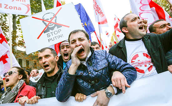 Люди кричат лозунги во время митинга оппозиции в знак протеста против политики России в отношении Грузии и Украины в Тбилиси, 15 ноября 2014
