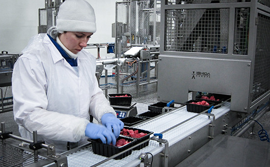 Рабочий упаковывает готовую продукцию (мясо крупного рогатого скота) на предприятии агропромышленного холдинга