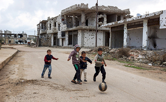 Дети играют возле разрушенных зданий в сирийском городе ​Босра Аль-Шам


