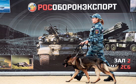 Сотрудница полиции на фоне плаката «Рособоронэкспорта»