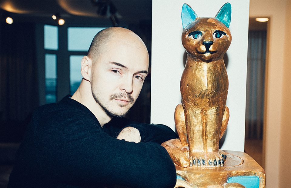 Дмитрий Волков у скульптуры «Триумф кота» работы Александра Повзнера
