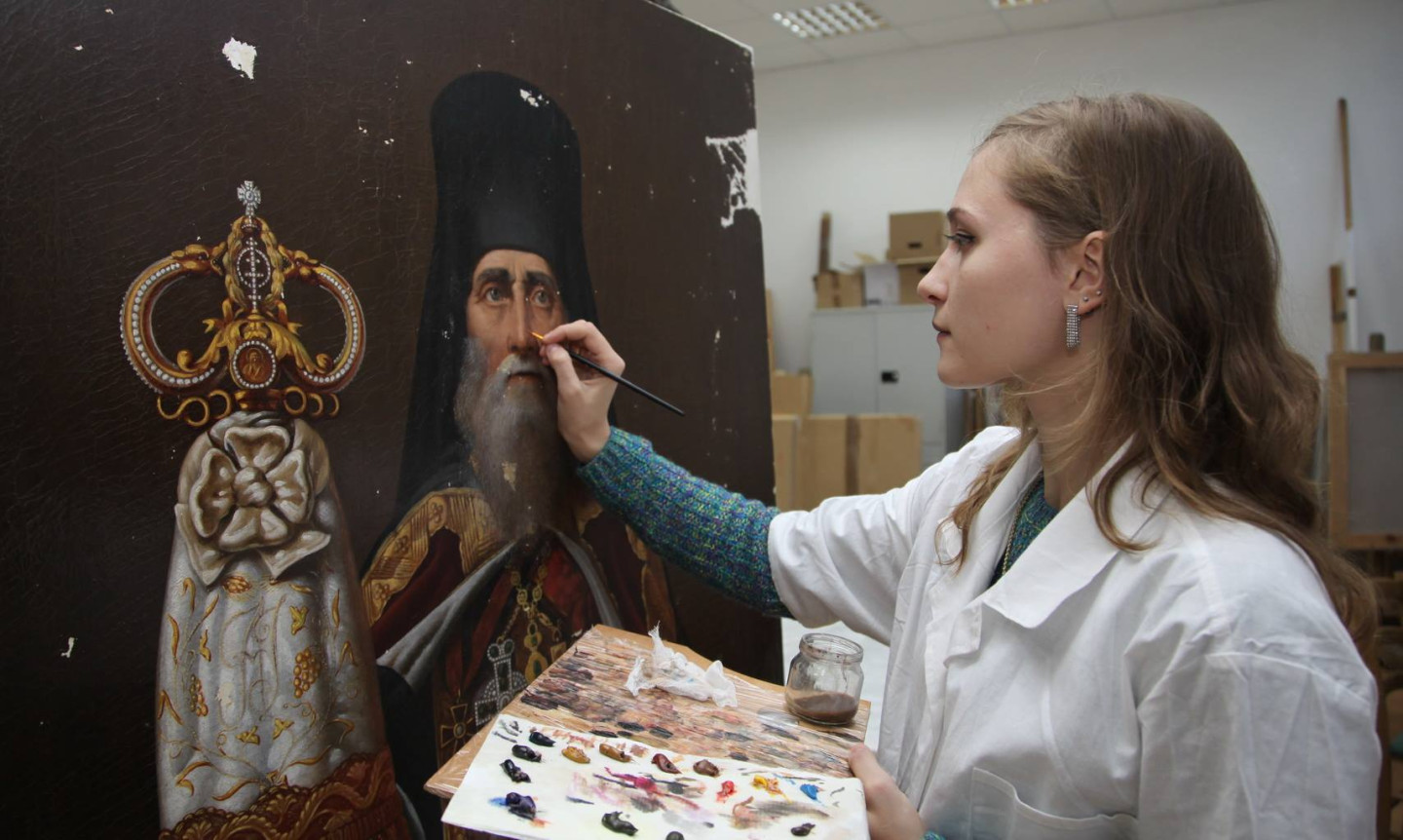 Инга Федорова в процессе реставрации картины «Портрет священнослужителя»