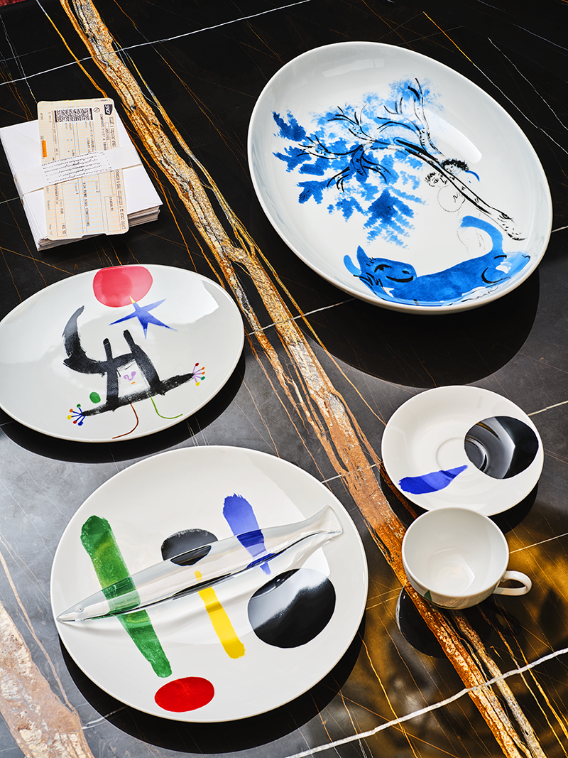 Овальное блюдо L’Animal Vert, коллекция Marc Chagall, Bernardaud (ЦУМ), тарелки и чайная пара с орнаментами Parler Seul — Joan Miró, Bernardaud (ЦУМ), стол Sahara Noir, Draenert (салон «Частная коллекция»)