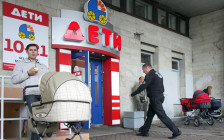 Мужчина с коляской стоит перед входом в магазин «Дети». Санкт-Петербург, 2009 год
