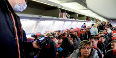 Сотрудник Роспотребнадзора проверяет тепловизором пассажиров, прибывших рейсом из вьетнамского города Камрань в Красноярск