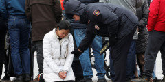 Полицейский успокаивает женщину, которая пришла к мемориалу у «Крокус Сити Холла»