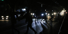 Жители Симферополя переходят дорогу в свете фар автомобилей