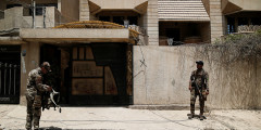 Солдат иракской армии стоит у дома в Мосуле, который, как оказалось, использовался террористами в качестве тюрьмы
