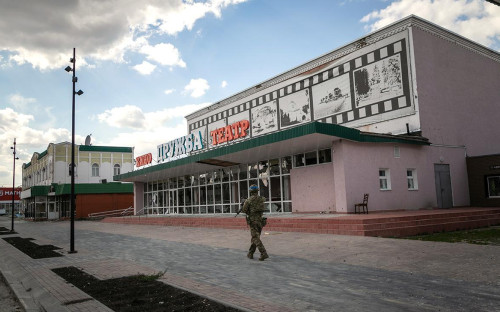 Украинский военнослужащий проходит мимо кинотеатра &laquo;Дружба&raquo;, поврежденного в результате боевых действий, Суджа, Курская область, Россия