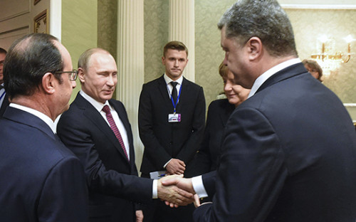 Президент России Владимир Путин и президент Украины Петр Порошенко пожимают друг другу руки во время встречи в Минске, 11 февраля 2015