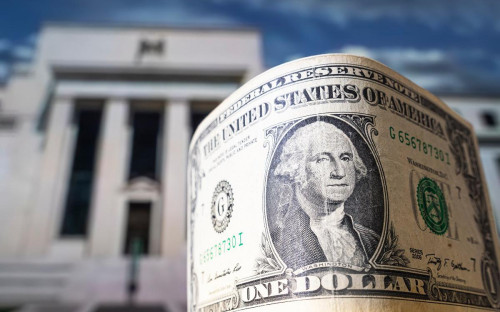 Доллар США на фоне здания ФРС в Вашингтоне