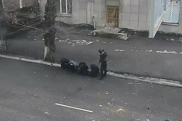В Алма-Ате в четверг задержали около 2 тыс. протестующих. На этом скриншоте с видео полицейский охраняет задержанных