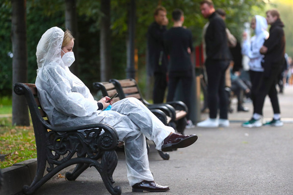 Девушка в защитном костюме на одной из улиц города, 12 сентября 2020 года