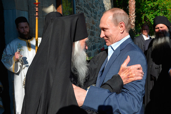 Владимир Путин и схиархимандрит Иеремия приветствуют друг друга в храме Успения Пресвятой Богородицы в Карее, административном центре Афона