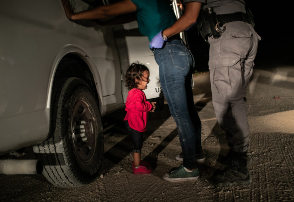 Автор: Джон Мур / Getty Images
Фото плачущей девочки Янелы Санчез из Гондураса было сделано в Техасе, США, в июне. Мур сфотографировал ребенка, когда его забирали у матери сотрудники органов опеки США.
Администрация Трампа объявила политику «нулевой толерантности» на границе, в соответствии с которой мигранты, пойманные на въезде в США, могут быть привлечены к уголовной ответственности. В результате многие задержанные родители были разлучены со своими детьми и часто направлялись в разные места содержания под стражей. После того как эта фотография была опубликована, таможенная и пограничная службы США заявили, что Янела и ее мать не были среди тысяч разделенных американскими чиновниками семей. Тем не менее протест по поводу этой спорной практики привел к тому, что президент Дональд Трамп 20 июня отменил свое решение.
Снимок победил также в номинации «Главная новость»