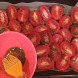 При помощи кулинарной кисти смажьте томаты оливковым маслом и отправьте в разогретую до 80 градусов духовку примерно на девять часов