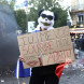 Участник протеста держит плакат во время демонстрации «Ты видишь, как я улыбаюсь, даже когда я подавлен», 18 октября 2026 года
