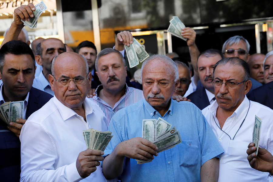 Турецкие бизнесмены перед пунктом обмены валюты в Анкаре. 14 августа 2018 года