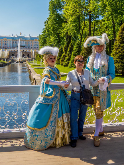 Туристка фотографируется с актерами в исторических костюмах в Петергофе