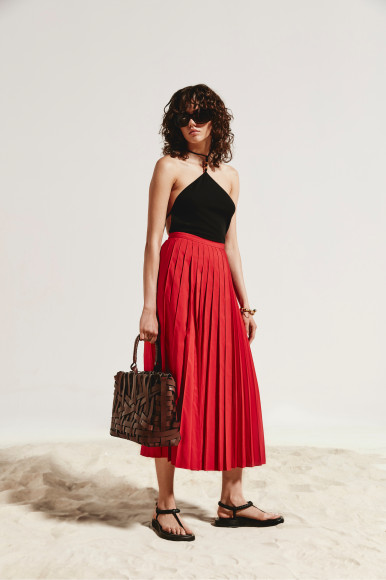 Боди Bottega Veneta, юбка Valentino, сумка Jil Sander, сандалии Gia Couture, очки Balenciaga, браслет Loewe